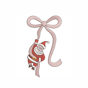May include: An embroidered design of Santa Claus hanging from a pink bow. Santa is wearing a red suit with white trim, a black belt, and a red hat. The bow is a soft pink color, and the background is white.
