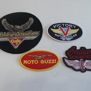 May include: Four embroidered motorcycle patches. A black Harley-Davidson patch with an eagle and "New York Cafe". A Victory Motorcycles patch with a red "V". A red Moto Guzzi patch. An Indian Motorcycle patch with wings.