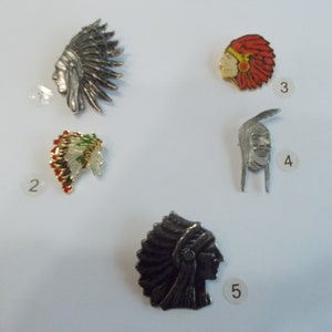 May include: Five different Native American headdress pins. The pins are made of metal and have different colours and designs.