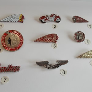 May include: Nine different Indian Motorcycle pins, featuring a variety of designs, including a motorcycle, a Native American head, and the Indian Motorcycle logo. The pins are numbered 1 through 9.