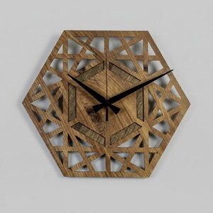 May include: Wooden wall clock with a geometric design. The clock face is a hexagon shape with a natural wood grain finish. The clock hands are black. The clock has a decorative, openwork design.