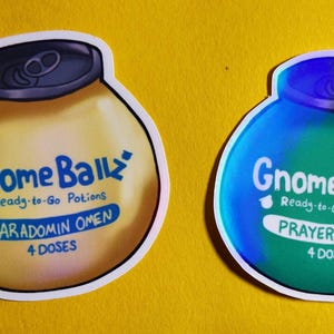 May include: Two stickers with a cartoon potion bottle design. One is yellow with the text "SARADOMIN OMEN" and the other is blue and green with "PRAYER AFFAIR". Both say "Gnome Ball" and "Ready-to-Go Potions".