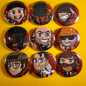May include: Nine round, red and brown character button pins with holographic glitter. Each pin features a different cartoon character with various expressions and outfits. The buttons are arranged in a three-by-three grid on a yellow background.