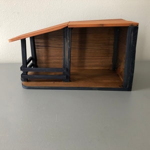May include: A wooden nativity scene with a black painted frame. The scene is empty and ready for figurines.