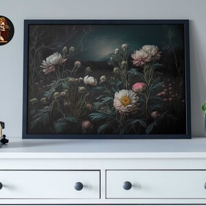 Op de afbeelding: Een ingelijste print van een donker, sfeervol bloemstilleven met witte en roze pioenen in een weelderige tuinsetting.