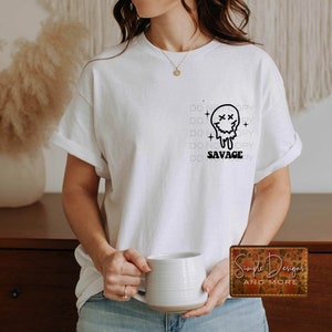 May include: White t-shirt with a black graphic of a melting smiley face with the text "DO NOT COPY" repeated and "SAVAGE" below the graphic.