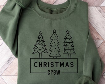May include: A green sweatshirt with a black graphic of three Christmas trees and the text "CHRISTMAS CREW".