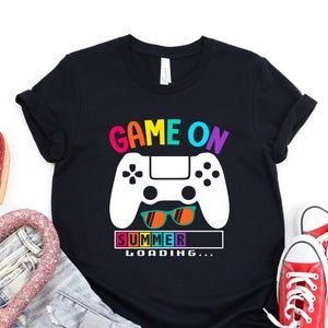 May include: Black t-shirt with a white video game controller graphic and the text "Game On Summer Loading..." in rainbow colors.