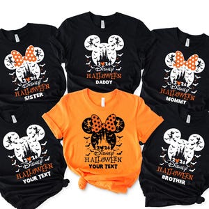 May include: A collection of five short-sleeved t-shirts in black and orange. Each shirt features a graphic of a Mickey Mouse silhouette containing a castle, bats, and a witch. Text includes 2026, Disney Halloween, and labels like Sister, Daddy, Mommy, Brother, or Your Text.