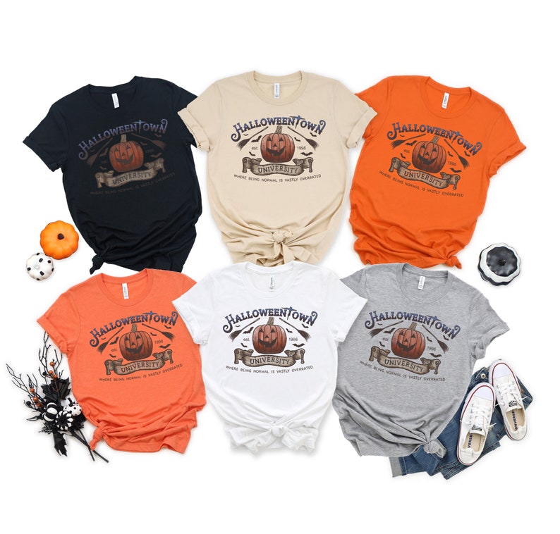May include: Six different color t-shirts with a Halloweentown University graphic featuring a jack-o-lantern, bats, and the text "Where being normal is vastly overrated".
