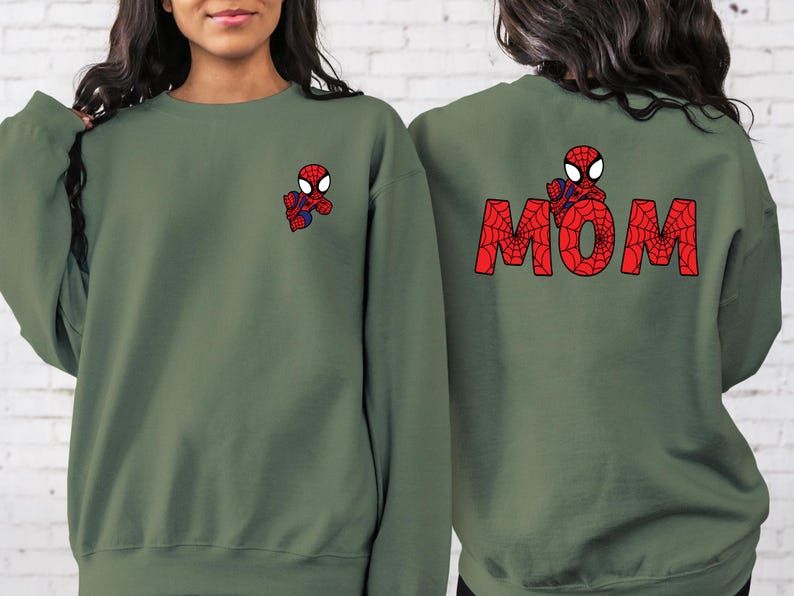 May include: Two green sweatshirts with a red and black Spiderman design. One sweatshirt has the word "MOM" spelled out in red and black Spiderman design.