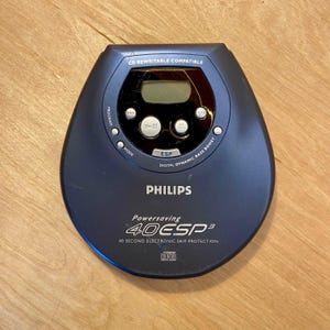 May include: A white ceramic mug with a black handle and the text "But First, Coffee" in a bold, black font. The mug is set against a blurred background, highlighting its clean design.