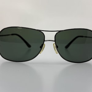 Puede incluir: Gafas de sol aviador negras con montura fina de metal y lentes oscuras.