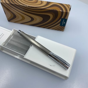 May include: A silver pen with a chrome clip and a white box with the text "FABER-CASTELL" and "Gebrauchsanweisung Instruction Manual".