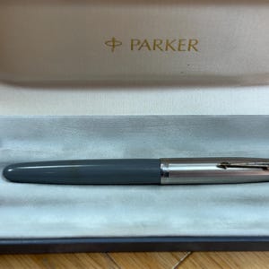Penna stilografica vintage Parker 51, corpo grigio, cappuccio in metallo, sistema aerometrico