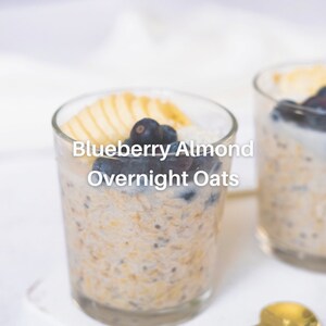 Puede incluir: Dos tarros de vidrio llenos de avena con ar&aacute;ndanos y almendras para la noche. La avena est&aacute; cubierta con rodajas de manzana y ar&aacute;ndanos.