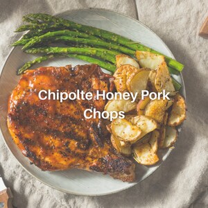 Puede incluir: Primer plano de un plato con una chuleta de cerdo a la parrilla, patatas asadas y esp&aacute;rragos. La chuleta de cerdo est&aacute; sazonada con un glaseado de miel y chipotle. El texto "Chipotle Honey Pork Chops" est&aacute; superpuesto en la imagen.
