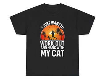 May include: Black t-shirt with a graphic design featuring a sunset scene with a person running with a dog, palm trees, and the text "I JUST WANT TO WORK OUT AND HANG WITH MY CAT."