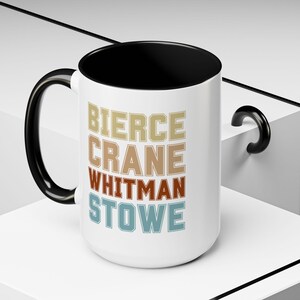 May include: White ceramic mug with a black rim and handle. The mug has a retro design with the names "Bierce", "Crane", "Whitman", and "Stowe" printed in different colors.