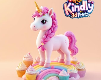 May include: A whimsical 3D-printed unicorn figurine with a pink mane and tail, a golden horn, and floral accents. The unicorn stands on a rainbow above cupcakes. The image includes the text "Kindly 3D Prints".