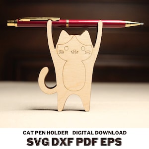 May include: A wooden cat-shaped pen holder with a red pen held in its arms. The cat is made of light-colored wood and has a simple, cartoonish design. The text "CAT PEN HOLDER DIGITAL DOWNLOAD SVG DXF PDF EPS" is at the bottom.