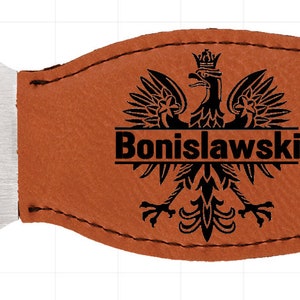 May include: A brown leather bottle opener with a silver metal opener and a black engraved Polish eagle with the name "Bonislawski" underneath.