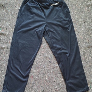May include: A pair of dark blue athletic pants with a white drawstring and the word "KARHU" printed on the left leg.