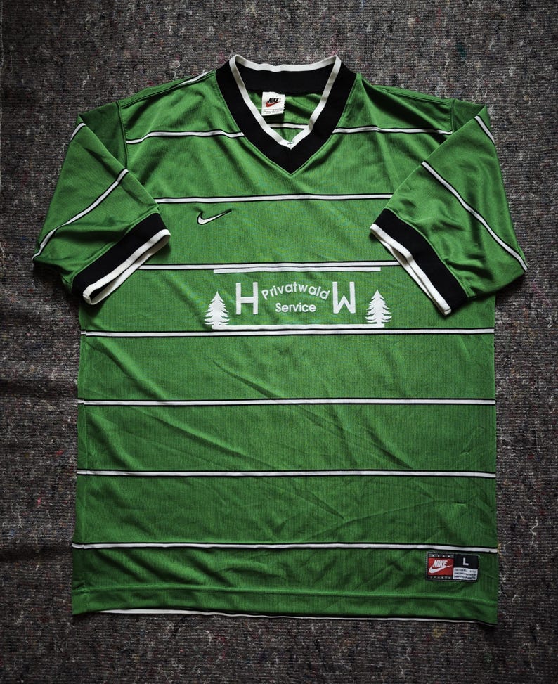 May include: Green and white striped jersey with a V-neck collar and short sleeves. The jersey features the text "Privatwald Service" and a Nike logo. The sleeves have black and white trim. The jersey is a size large.