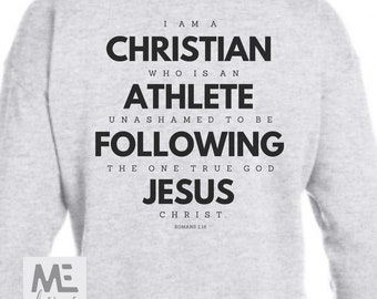 May include: Gray sweatshirt with black text that reads "I am a Christian who is an athlete unashamed to be following the one true God Jesus Christ. Romans 1:16"