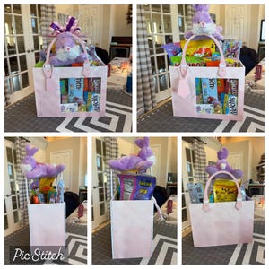 May include: A pink Easter gift basket with a plush purple bunny and assorted candies. The basket has a clear window showing the treats inside. The handle is pink and the basket is filled with snacks.