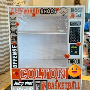 May include: A basketball-themed display box with the name "Colton" in bold letters. The box features basketball graphics, the words "Backboard Shoot", "Offense Rebound", "Block Net", "Hoops", "Jump Shot", "Lay-Up", and "Basketball".