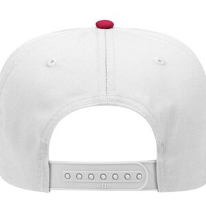 May include: White baseball cap with a red button on top. The cap has a white adjustable strap with the word "OTTO" printed on it.