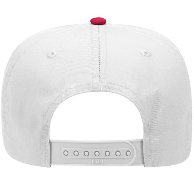 May include: White baseball cap with a red button on top. The cap has a white adjustable strap with the word "OTTO" printed on it.