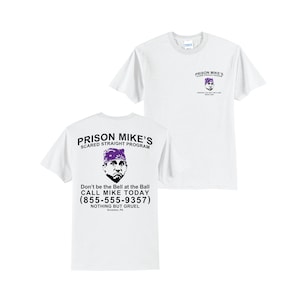 May include: White t-shirt with a graphic of a man's face with a purple bandana on his head. The text on the shirt reads "Prison Mike's Scared Straight Program" and "Don't be the Bell at the Ball Call Mike Today (855-555-9357) Nothing But Gruel"