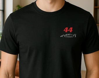 May include: Black t-shirt with a red "44" and a white outline of a race car. The shirt is a crew neck style and made of a soft material. The design is located on the upper left chest area.