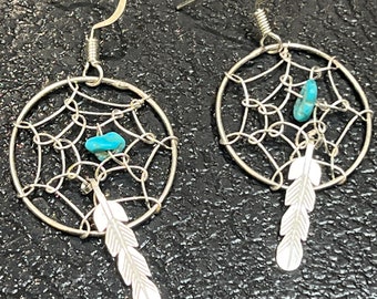 May include: Silver dreamcatcher earrings with turquoise stones and a feather charm.