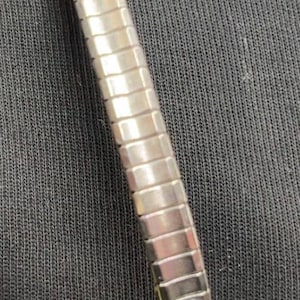 May include: Silver watch strap with a rectangular link design. The strap has decorative ends with turquoise-coloured stones and leaf-like embellishments. The watch strap is shown against a dark background.