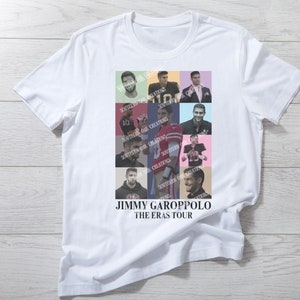 Puede incluir: Una camiseta blanca con un collage de fotos de Jimmy Garoppolo con diferentes uniformes. El texto "JIMMY GAROPPOLO THE ERAS TOUR" está impreso debajo de las fotos.