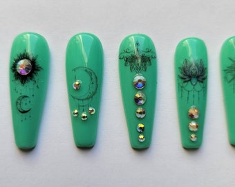 Press on nails turquoise with lotus blossoms, suns and moons accented with rhinestones