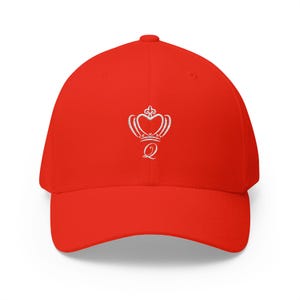 May include: A bright red baseball cap featuring a white embroidered crown design with the letter "Q" below it. The cap has a curved brim and a rounded crown, offering a classic, casual style.