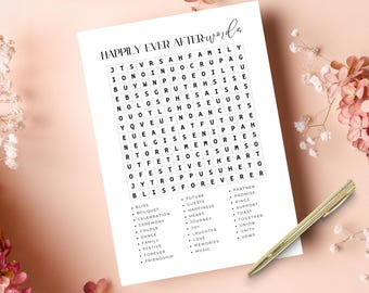 Peut inclure: Une feuille de jeu en papier blanc intitulée HAPPILY EVER AFTER words avec une grille de mots mêlés et une liste de mots sur le thème du mariage. Un stylo doré est placé en diagonale sur le coin inférieur droit du papier.