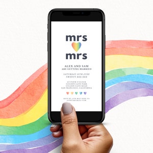 May include: A smartphone displays a wedding invitation with the text "mrs mrs" above a rainbow heart. The invitation reads "Alex and Sam are getting married" with event details. A watercolor rainbow design is in the background.