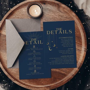 Puede incluir: Dos tarjetas de invitación de boda azul oscuro con texto dorado y gráficos celestiales, incluyendo un sobre gris. Una tarjeta se titula THE DETAILS y la otra THE DETAIL, con iconos de horario e información sobre alojamiento y regalos.