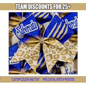 May include: Cheerleading bows in blue, gold, and white with the text "Sabercats". The bows have a leopard print pattern and glitter accents. The image also includes the text "Team Discounts for 25+" and "Custom Colors and Text".