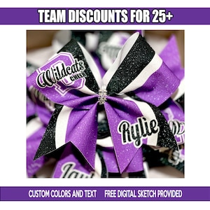 Op de afbeelding: Een aangepaste cheerleading strik in paars, zwart en wit met glitteraccenten. De strik heeft de tekst "Wildcats CHEER" en een naam, "Rylie". De afbeelding bevat ook de tekst "TEAMKORTINGEN VOOR 25+" en "AANGEPASTE KLEUREN EN TEKST GRATIS DIGITALE SCHETS VERSTREKT".