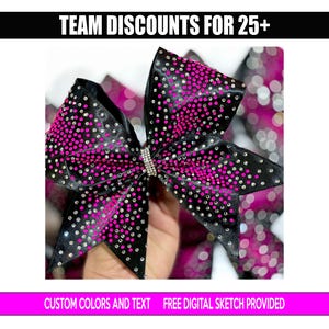 May include: Black and pink cheerleading bow with rhinestones. The bow has a rhinestone center and is decorated with pink and silver rhinestones. The image also includes the text "TEAM DISCOUNTS FOR 25+" and "CUSTOM COLORS AND TEXT FREE DIGITAL SKETCH PROVIDED."