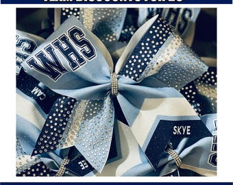 May include: Light blue and white cheerleading bow with the text "WHS" in navy blue. The bow is decorated with rhinestones and has a silver band in the center. The image also includes the text "SKYE". The text "TEAM DISCOUNTS FOR 25+" and "CUSTOM COLORS AND TEXT FREE DIGITAL SKETCH PROVIDED" are also visible.