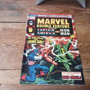 May include: A Marvel Double Feature comic book, issue number 4, featuring Captain America and Iron Man. The cover art depicts Captain America in a battle against the Red Skull, with text reading He Who Holds The Cosmic Cube and The Mystic Menace of the Red Skull.