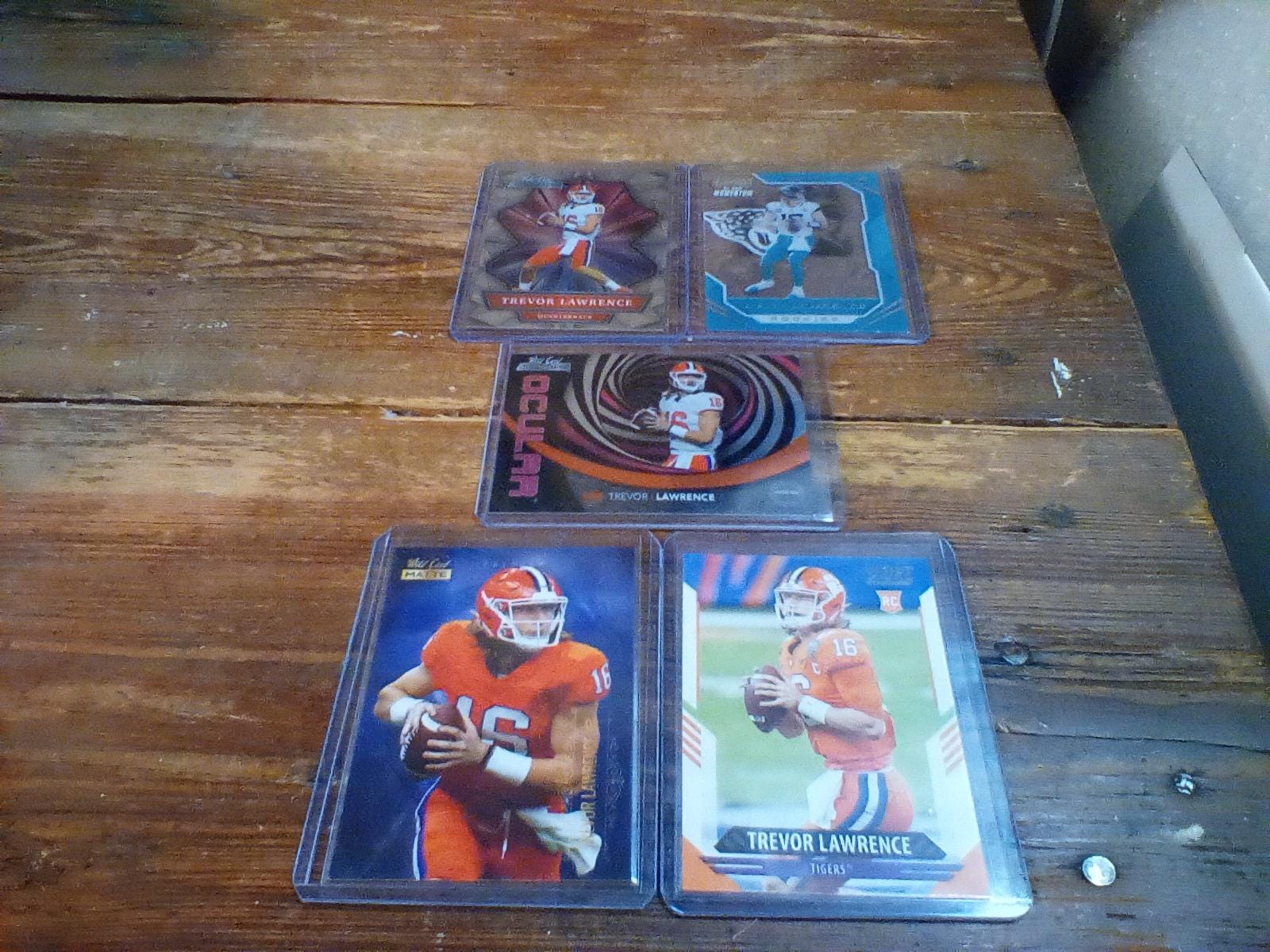 bundle of 5 trevor Lawrence football cards 2021 chronicles #pmr-1, 2021 wild card mbc-1, 2021  allumination abc-1, and oc-1 ,2021 score #301