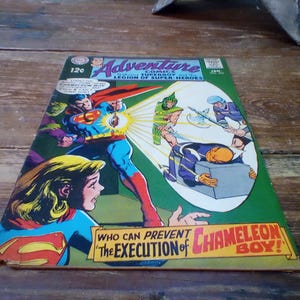 Puede incluir: Portada de cómic vintage de Adventure Comics con Superman y la Legión de Superhéroes. La portada muestra a Superman en acción, con el texto "Who Can Prevent The Execution of Chameleon Boy!"